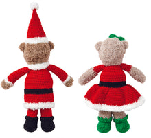 Load image into Gallery viewer, The back of two crocheted toy bears. One dressed as Santa with the back of its red and white fur trimmed bobble hat, fur trimmed long red tunic, red trousers and black boots. Mrs Claus is wearing a fur trimmed dress, green boots and a green hair bow