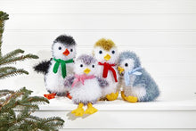 Load image into Gallery viewer, 4 tinsel penguins. All have white faces and fronts. Head top, back and wings are black, purple, gold or blue tinsel. The black penguin has an orange beak and feet, the others are yellow DK yarn. Red, blue, pink and green scarves in seed stitch
