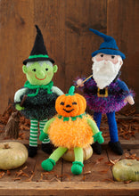 Load image into Gallery viewer, Image of a hand-knitted witch with green face, green and white striped stockings, a black tinsel body and black hat. The wizard is purple with a purple tinsel body and the pumpkin is orange tinsel with an orange pumpkin head and green arms and legs