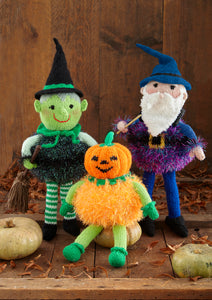 Image of a hand-knitted witch with green face, green and white striped stockings, a black tinsel body and black hat. The wizard is purple with a purple tinsel body and the pumpkin is orange tinsel with an orange pumpkin head and green arms and legs
