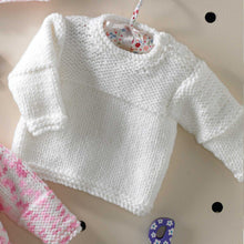 Load image into Gallery viewer, Image of white baby sweater knitted in white King Cole chunky yarn. The bands are and top half of the sleeves and front are knitted in garter stitch. The lower sleeves and front are knitted in stocking stitch. The left shoulder had a button opening
