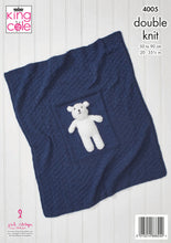 Load image into Gallery viewer, Image of a navy baby blanket. It has a diamond pattern knitted using garter stitch on to of stocking stitch - subtle because it is knitted all in one colour. There is a plain panel in the centre on which a white teddy bear is sewn