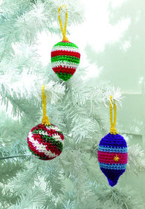 3 crocheted Christmas tree baubles. All have a gold hanging loop attached to a gold tip. 1 bauble is self-striping yarn - red, green and white with a sparkle thread. 1 is red, green and white stripes and the other is elongated in blues and red