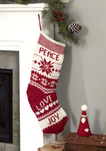 Load image into Gallery viewer, Scandinavian style knitted Christmas stocking and cone shaped red santa toy with a white hard motif and pom pom. The stocking is knitted in white and red DK yarn with panels of snow flakes, zig zags and the words Peace, Love and Joy
