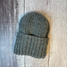 Load image into Gallery viewer, Hand knitted grey aran beanie with deep rib turnback. The main section of the hat is knitted in fisherman's rib for a thick, chunky rib effect. Knitted using King Cole pattern 3461 and graphite Fashion Aran yarn