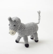 Load image into Gallery viewer, Crocheted donkey in light grey yarn. Its nose is white with 2 black nostril details and black bead eyes. His ears and tail are light grey and his hooves are black