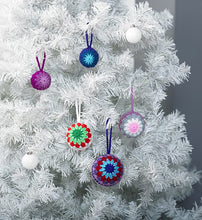 Load image into Gallery viewer, White Christmas tree with colourful crocheted bauble decorations. 3 have a coloured centre and then Granny square-like rows. The smaller ones have a multi-pointed star centre and two contrasting coloured rows
