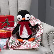 Load image into Gallery viewer, Crocheted penguin toy with large white eyes with black bead centres. It has an orange beak and feet. Its stomach is a large white circle. With black wings, the penguin is finished with a fluffy red scarf