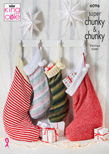 Load image into Gallery viewer, Image of cover of King Cole knitting pattern 6096 showing four Christmas stockings - two large and predominantly red, two small with a self stripe effect created by the super chunky yarn
