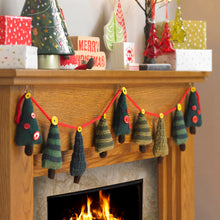 Load image into Gallery viewer, Festive mantlepiece with Christmas tree knitted bunting. Trees are attached to a red knitted cord with yellow buttons. There are 4 Xmas tree designs - dark green with red buttons, dark and light green stripes, dark and olive green stripes, dark green
