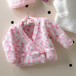 Image of crossover cardigan knitted in King Cole Comfort chunky yarn. The yarn is white with flecks of two shades of pink. The bands and cuffs are deep and knitted in garter stitch along with the front bands. The rest is knitted in stocking stitch