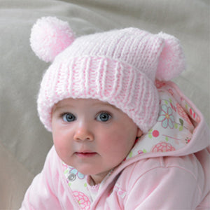 This baby is wearing a super cute pink tea bag hat in chunky baby yarn. Hand knitted with a rib turn back and stocking stitch main section. The main hat is a square shape and finished with a pom pom on each corner. The weight folds it over 