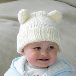 The baby in this image is wearing a super cute chunky teddy bear hat. Hand knitted in cream chunky baby yarn, this hat features a rib turn back and is finished with two 'ears' 