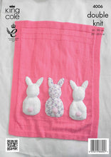 Load image into Gallery viewer, Image of bright pink hand knitted baby blanket. Knitted in stocking stitch with garter stitch border. It also has two lines across the top and bottom in garter stitch. At the bottom of the main section are 3 fur rabbit backs with bobble contrast tail
