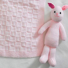 Load image into Gallery viewer, Close up of pale pink knitted rabbit toy. Hand knitted in garter stitch with pink embroidered nose and mouth and black eyes. Fronts of ears are a bright pink. You can also see the square texture of the baby blanket
