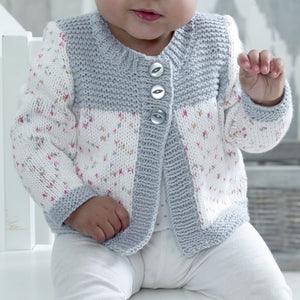 Image of a close up of the long sleeve cardigan. Cuffs and bands are knitted in silver cotton yarn. Sleeves and main sections of the fronts are knitted in white yarn with pink and silver flecks. Top of the fronts is knitted in silver garter stitch