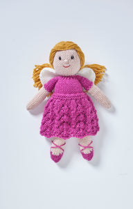 A hand knitted fairy toy. She wears dark pink ballet style shoes with cross straps. Her dress is dark pink, the skirt is knitted in a wavy stitch and it has short sleeves. White wings and gold hair tied back finish her look 