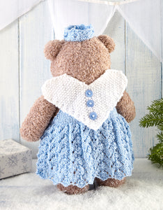 Image of the back of the Christmas fairy dressed up teddy bear. The wings are knitted in moss or seed stitch in white yarn. The main piece is a white love heart shape with 3 light blue buttons down the centre. You can see the back of the lacy dress