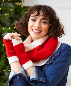 Woman wearing Santa themed snood and wrist warmers or fingerless gloves. Both are knitted in bright red yarn with white rib bands