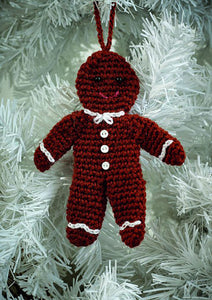 Crocheted gingerbread man Christmas tree ornament., Crocheted in a rich brown yarn with matching hanging hook. Black bead eyes and a pink embroidered mouth. White chains at his neck, wrists and ankles look like icing. 3 white buttons down his front