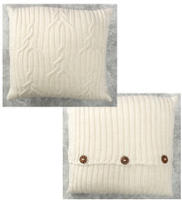 Load image into Gallery viewer, A simple cable design cushion or pillow knitted in white yarn. The knots and twists look a little like antlers. On the back, the two pieces are closed about a third up from the bottom with round wooden buttons
