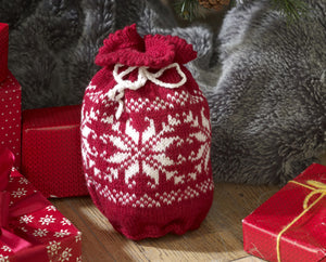 A red gift bag with white drawstring. The body of the bag has rows of contrasting white stitches in snowflake motifs. The picot edging at the top gives a lovely finish