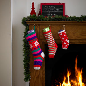 3 Christmas stockings. Large with white, red, purple, pink and green stripes. The leg panel is red with white snowflakes, green and purple hearts. Medium size stocking in red, green and white stripes. Small stocking in red with white diamonds