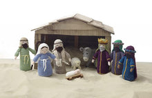 Load image into Gallery viewer, A crocheted nativity set picture on sand in front of a wooden stable. Joseph, Mary, babyJesus, donkey, sheep, shepherd and the 3 wise men. All wear robes and head dresses. One wise man has a crown and all the men have beards
